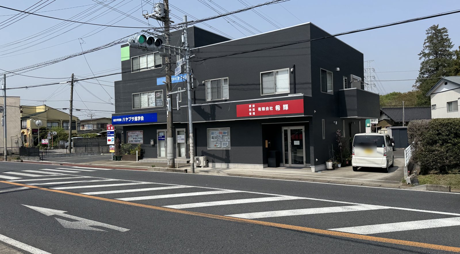 大網街道から見た有限会社希輝の事務所の建物。2階建てで赤い看板がある