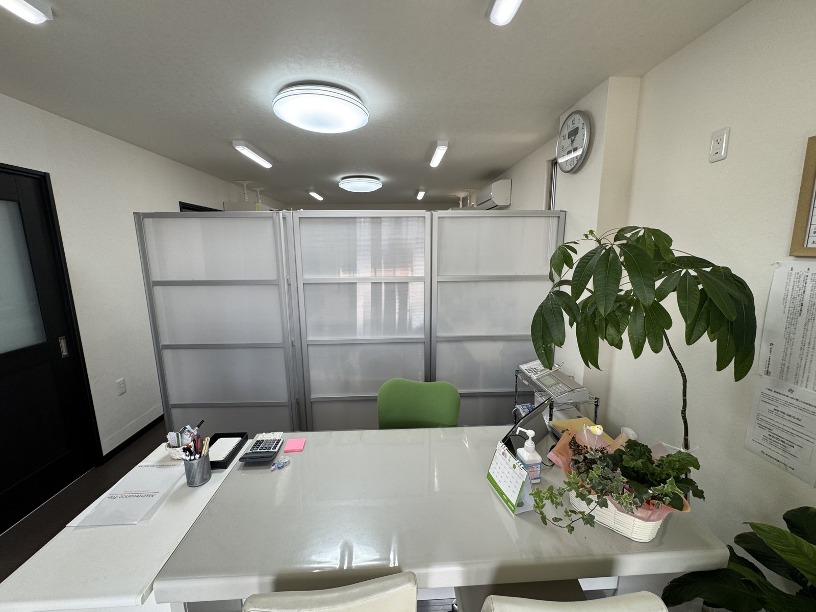 事務所の中。白い机と観葉植物