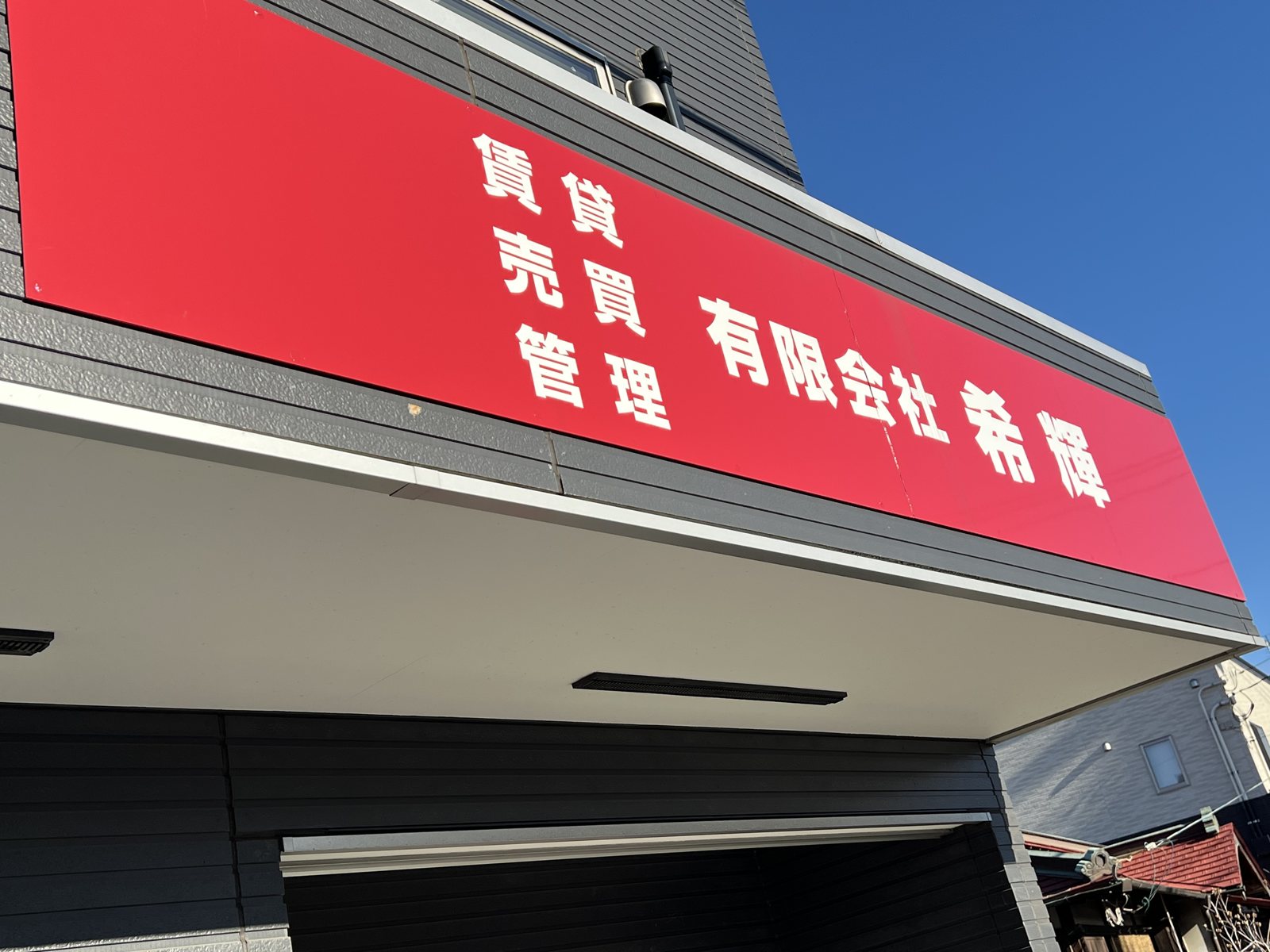 有限会社希輝の赤い看板。賃貸・売買・管理と書いてある
